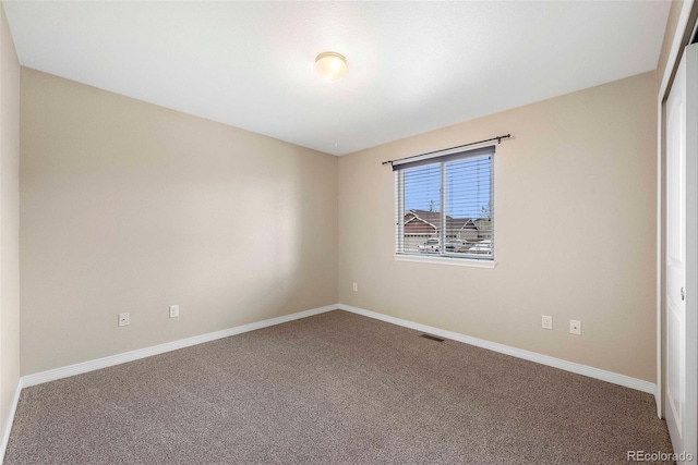 carpeted empty room with visible vents and baseboards