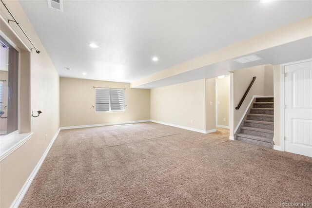 basement featuring visible vents, baseboards, stairway, recessed lighting, and carpet