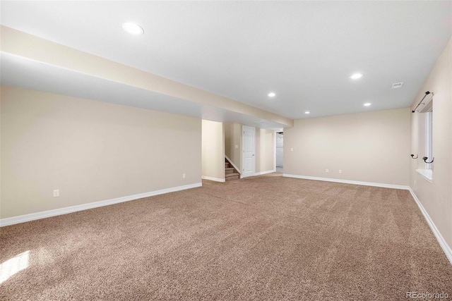 finished below grade area featuring recessed lighting, stairs, baseboards, and light carpet