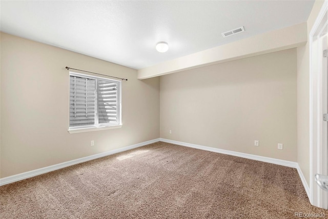 spare room with baseboards, carpet, and visible vents