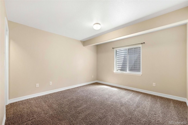 carpeted empty room featuring baseboards
