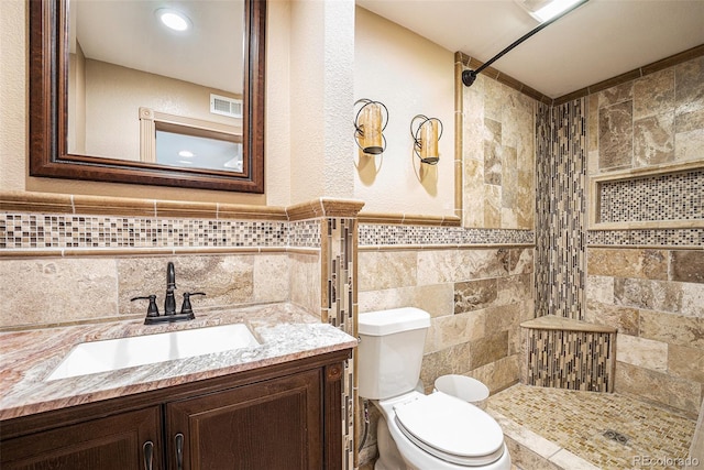 19523 E Buchanan Pl, Aurora, CO 80011 - bathroom with tile walls, a tile shower, toilet, vanity, and wainscoting