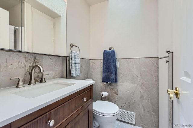 8644 S Brentwood St, Littleton, CO 80128 - half bathroom featuring vanity, tile walls, and wainscoting