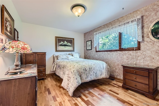 8644 S Brentwood St, Littleton, CO 80128 - bedroom with wallpapered walls, light wood-style floors, and an accent wall