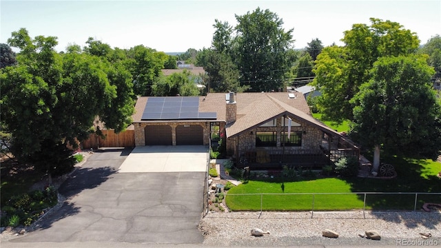 8644 S Brentwood St, Littleton, CO 80128 - view of front facade with stone siding, a garage, concrete driveway, solar panels, and a chimney