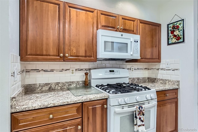 8644 S Brentwood St, Littleton, CO 80128 - kitchen featuring white appliances, brown cabinets, and tasteful backsplash