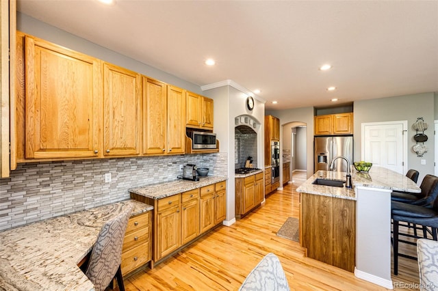 22685 E Calhoun Pl, Aurora, CO 80016 - kitchen with a sink, appliances with stainless steel finishes, recessed lighting, arched walkways, and a breakfast bar area