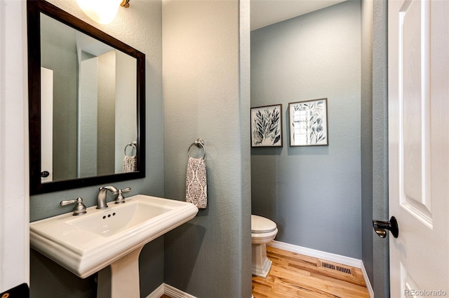 22685 E Calhoun Pl, Aurora, CO 80016 - half bathroom featuring toilet, wood finished floors, baseboards, and a textured wall