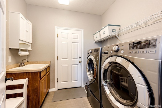 22685 E Calhoun Pl, Aurora, CO 80016 - laundry area with washing machine and clothes dryer, light tile patterned floors, and cabinet space
