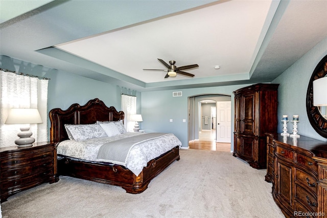 22685 E Calhoun Pl, Aurora, CO 80016 - bedroom featuring a raised ceiling, arched walkways, light colored carpet, and ceiling fan
