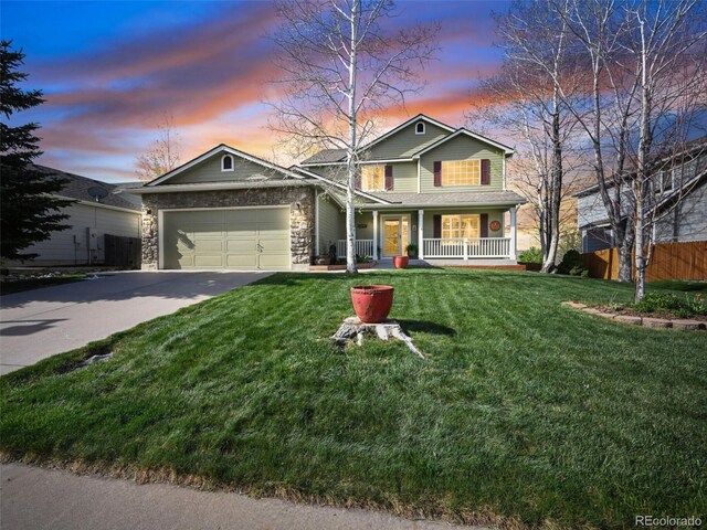 traditional home with covered porch, concrete driveway, a garage, and stone siding