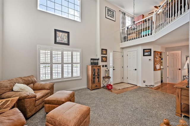 living area with a high ceiling, plenty of natural light, and baseboards