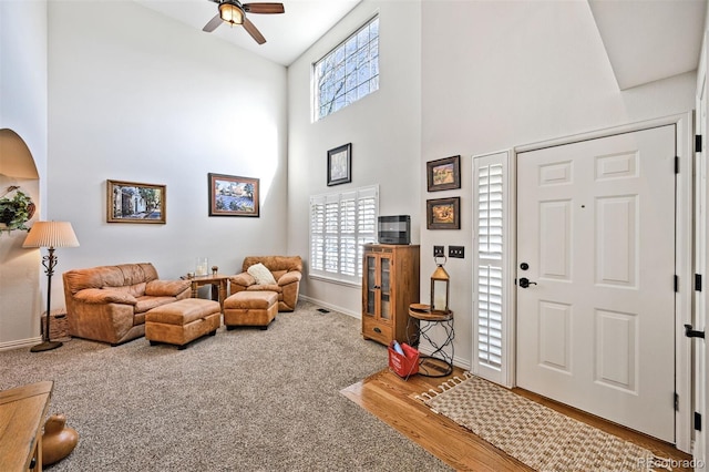 foyer entrance featuring high vaulted ceiling, a ceiling fan, baseboards, and wood finished floors
