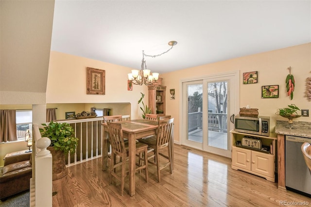 dining room with light wood finished floors and a chandelier
