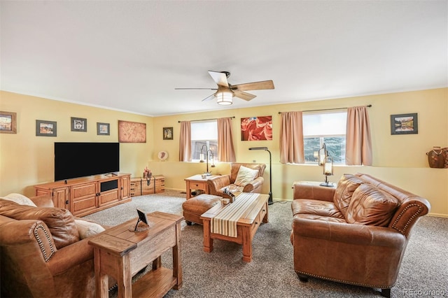 living area with carpet floors, ceiling fan, healthy amount of natural light, and baseboards