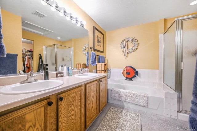 bathroom featuring a shower stall, a bath, double vanity, and a spacious closet