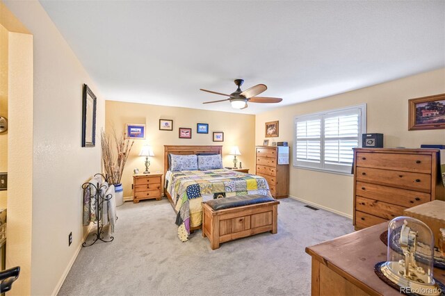 bedroom with light colored carpet, baseboards, and a ceiling fan