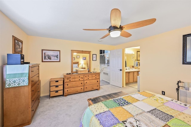 bedroom with light carpet, ceiling fan, and ensuite bath