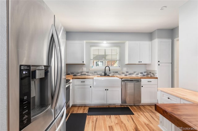 kitchen with wood counters, stainless steel appliances, and a sink