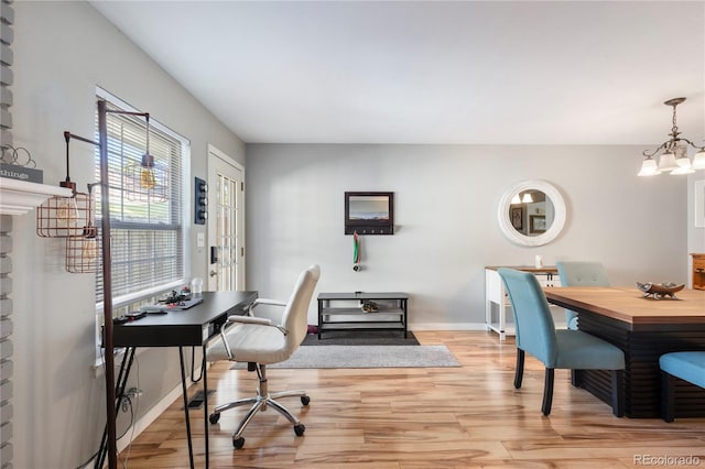 home office featuring baseboards, light wood finished floors, and an inviting chandelier