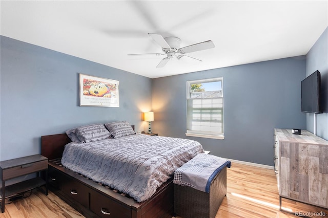 bedroom featuring light wood-type flooring, baseboards, and a ceiling fan