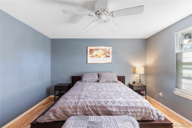 bedroom with wood finished floors, a ceiling fan, and baseboards