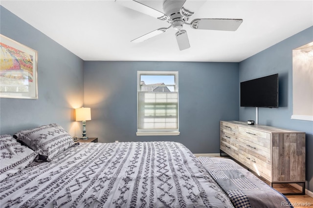 bedroom featuring a ceiling fan, baseboards, and wood finished floors