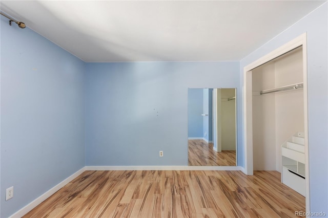 unfurnished bedroom featuring a closet, baseboards, and wood finished floors