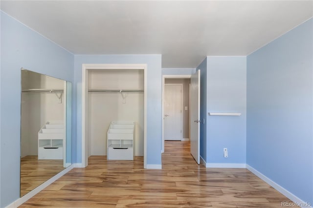 unfurnished bedroom with light wood-style flooring and baseboards