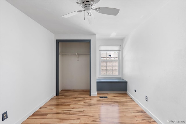 unfurnished bedroom with light wood-style flooring, visible vents, a ceiling fan, baseboards, and a closet