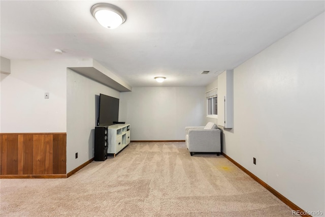 interior space featuring baseboards, visible vents, wainscoting, light colored carpet, and wood walls