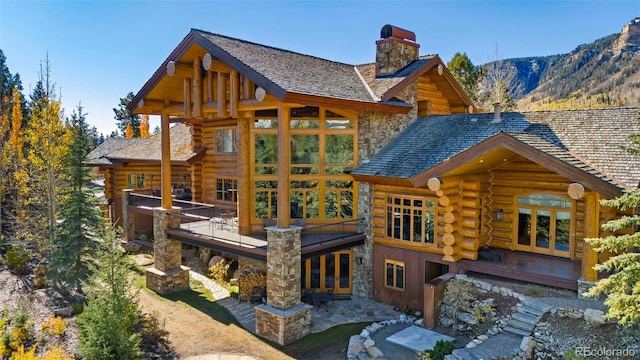 rear view of property featuring a mountain view, french doors, and a patio