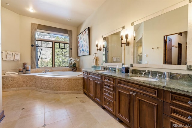 bathroom featuring tile patterned floors, vanity, and a relaxing tiled tub