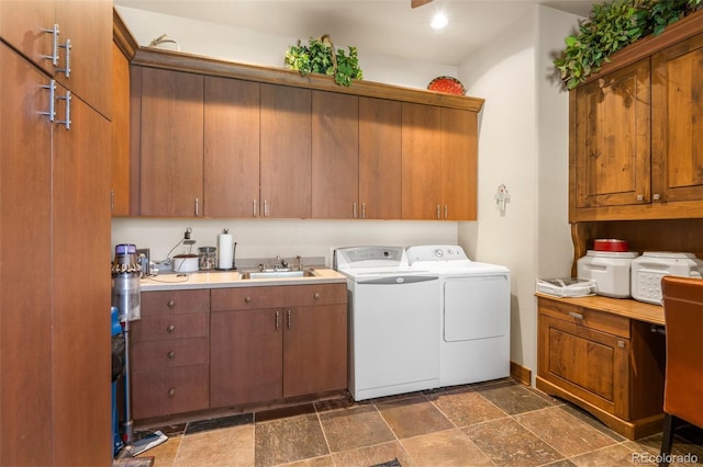 clothes washing area featuring cabinets, washing machine and dryer, and sink