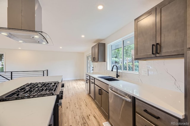 kitchen featuring sink, light hardwood / wood-style flooring, stainless steel dishwasher, tasteful backsplash, and island exhaust hood