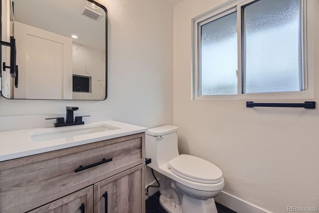 bathroom featuring toilet and vanity