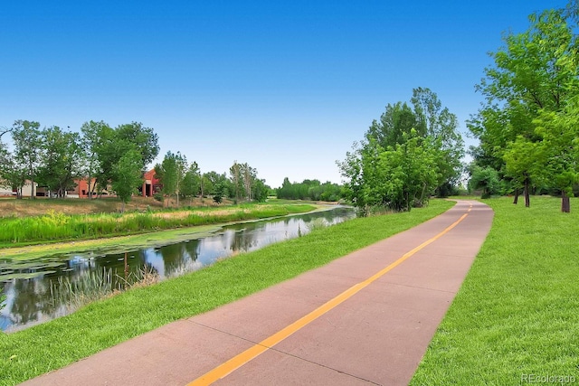 view of community with a lawn and a water view