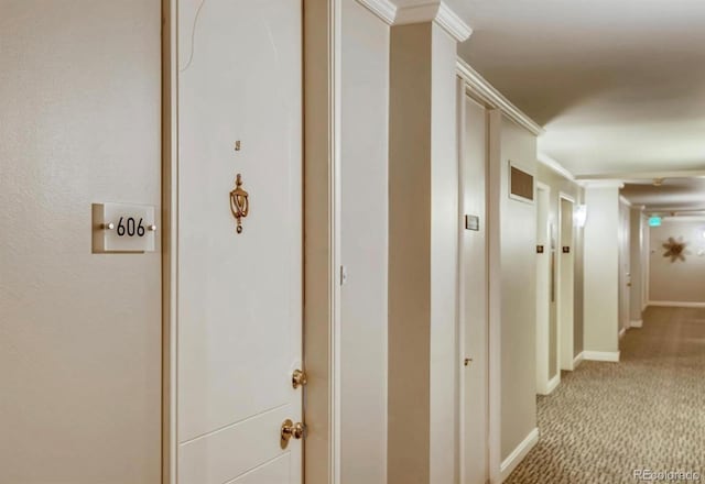 hallway featuring crown molding and light colored carpet