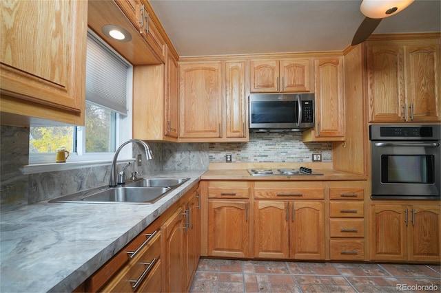 kitchen featuring decorative backsplash, stainless steel appliances, and sink