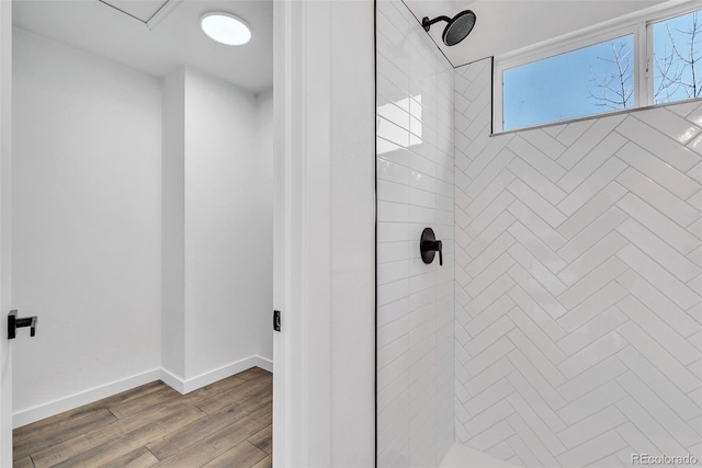 bathroom with wood-type flooring and tiled shower