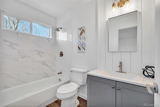 full bathroom featuring vanity, wood-type flooring, toilet, and tiled shower / bath