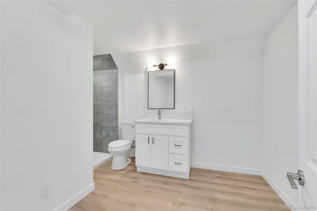 bathroom with hardwood / wood-style flooring, vanity, toilet, and walk in shower