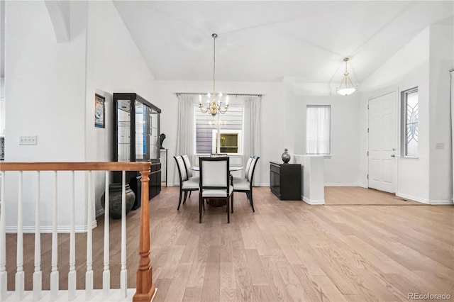 dining area featuring a chandelier, wood-type flooring, and lofted ceiling