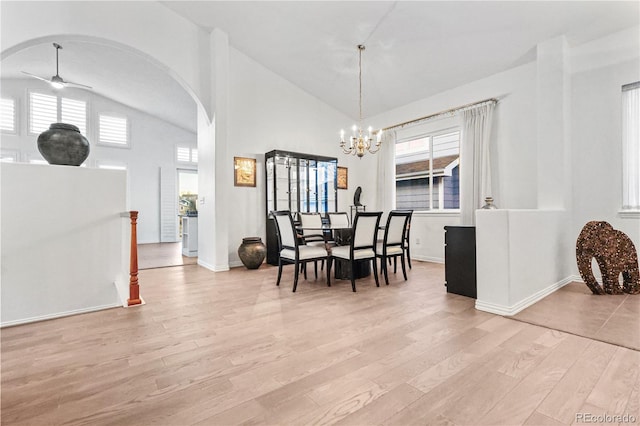 dining area featuring ceiling fan with notable chandelier, light hardwood / wood-style floors, and high vaulted ceiling