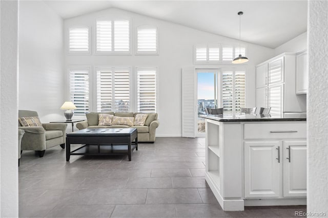 interior space with high vaulted ceiling, light tile patterned floors, and a wealth of natural light