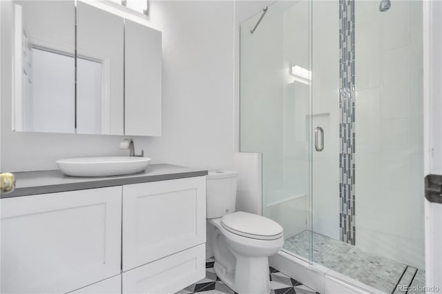 bathroom featuring tile patterned floors, vanity, toilet, and walk in shower