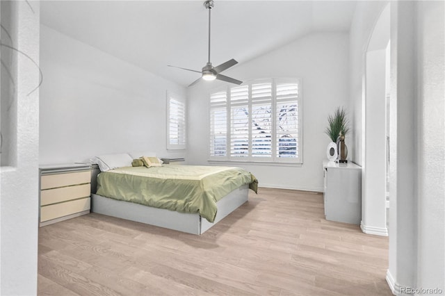 bedroom with light hardwood / wood-style flooring, vaulted ceiling, and ceiling fan