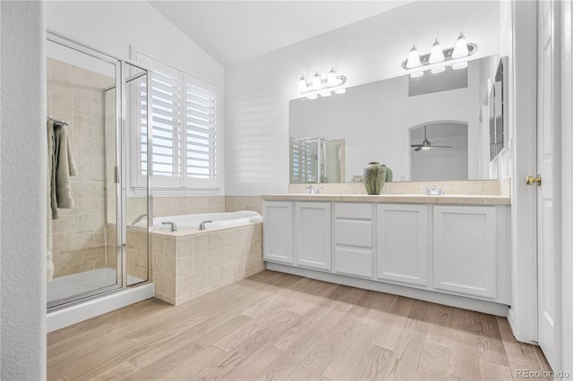 bathroom featuring vanity, ceiling fan, wood-type flooring, and plus walk in shower