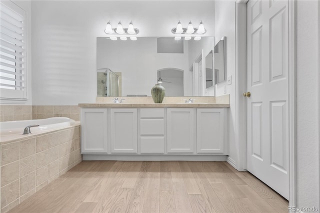 bathroom with vanity, plus walk in shower, and hardwood / wood-style flooring