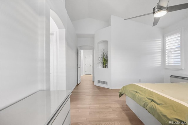 bedroom featuring light hardwood / wood-style floors, vaulted ceiling, and ceiling fan